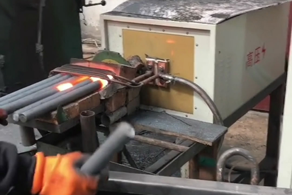 中頻鍛造加熱爐配自動送料系統(tǒng)對金屬棒材（如鐵棒、銅棒、鋁棒）的加熱和鍛造(圖1)